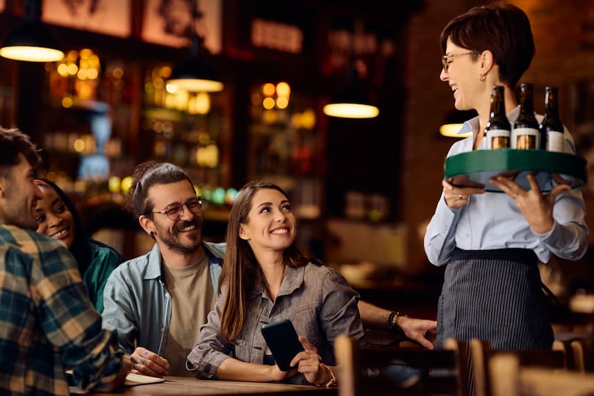 Waitress serving drinks to group of people