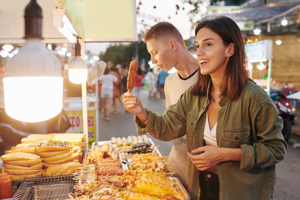 Woman holding food at street food stall